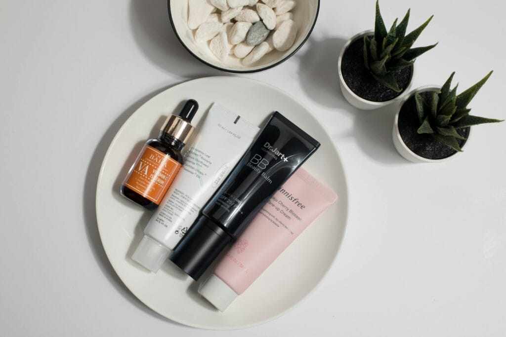 Elevate your skincare routine with this minimalist product display featuring various cosmetics on a white plate.